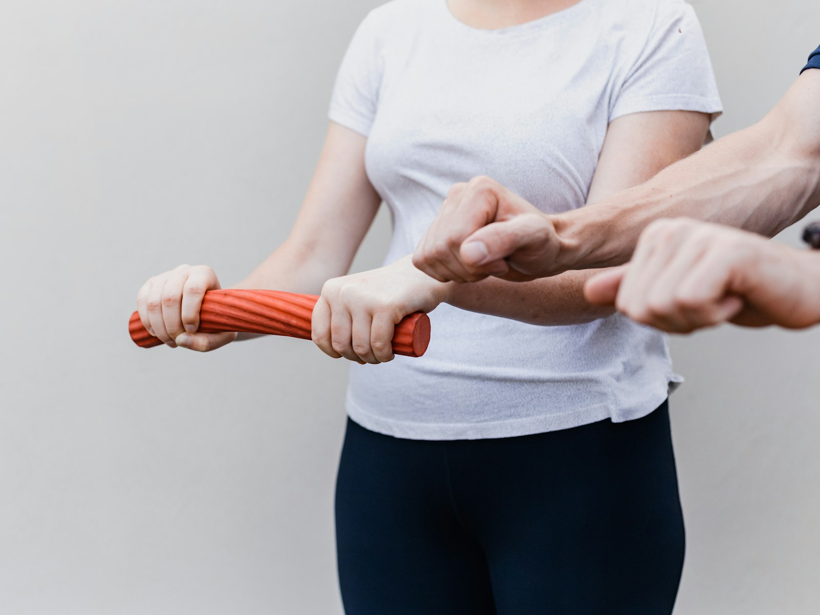 A patient practices a resistance exercise while a therapist supervises