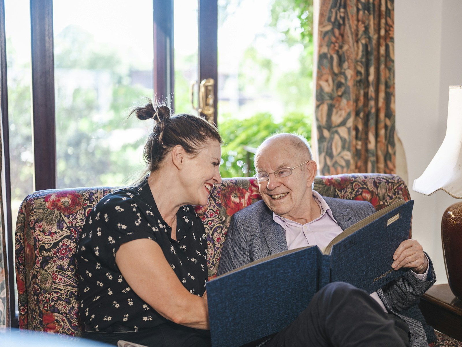 An older couple sitting together on a couch at home