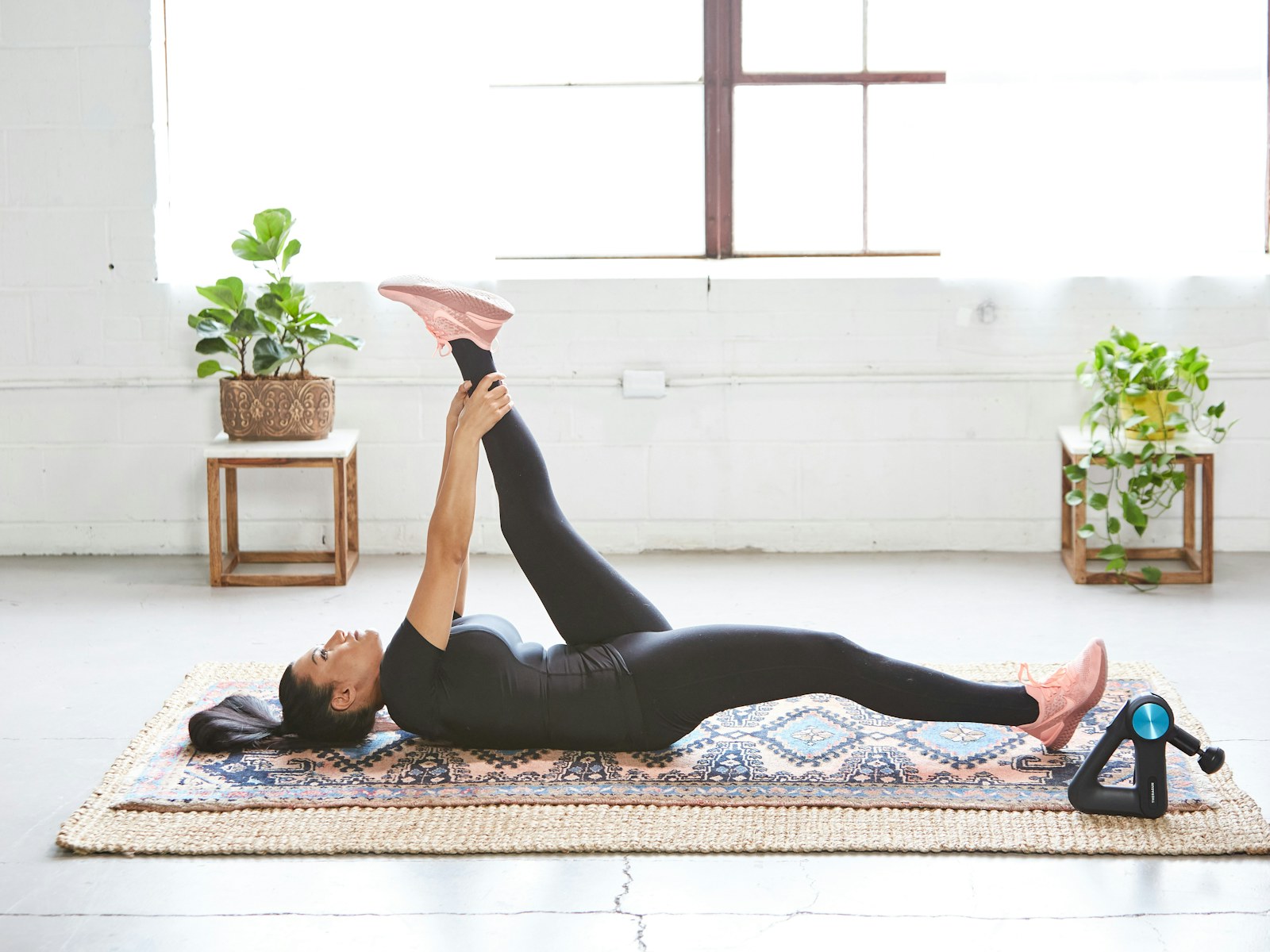 A woman doing a stretching exercise on the floor at home