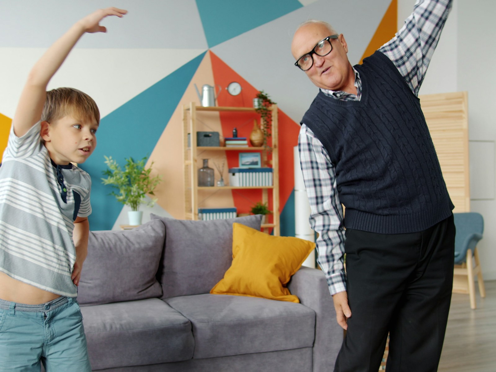 A grandfather and grandson exercising together indoors