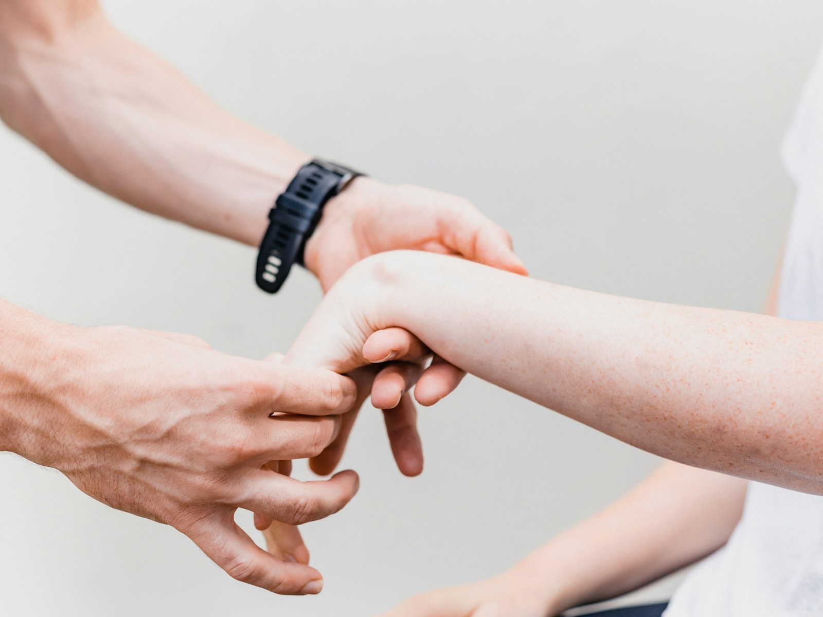 A therapist steadies a patient's hands during an exercise