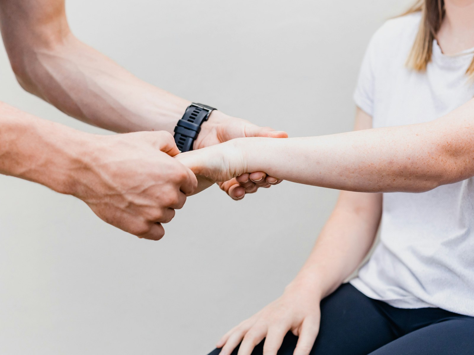 A therapist and patient holding hands for support