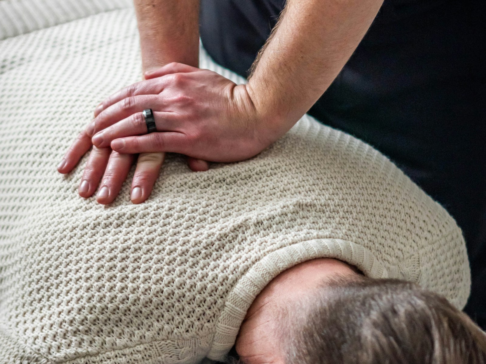 A clinician treats a patient's upper back and neck
