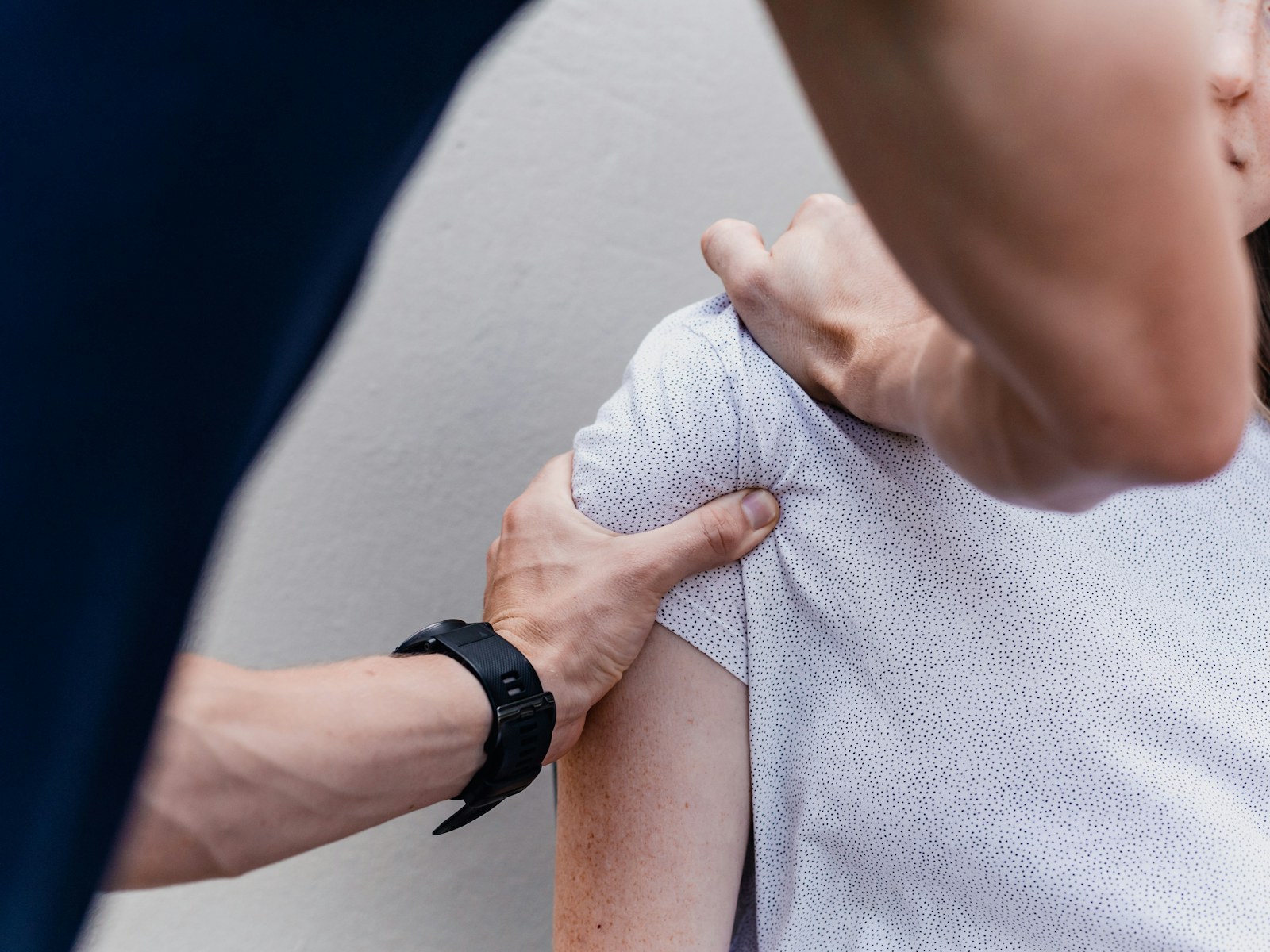 A therapist works on a patient's shoulder