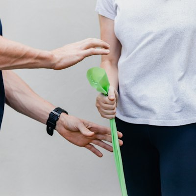 A patient squeezing a therapy ball to build grip strength