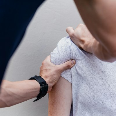 A therapist works on a patient's shoulder