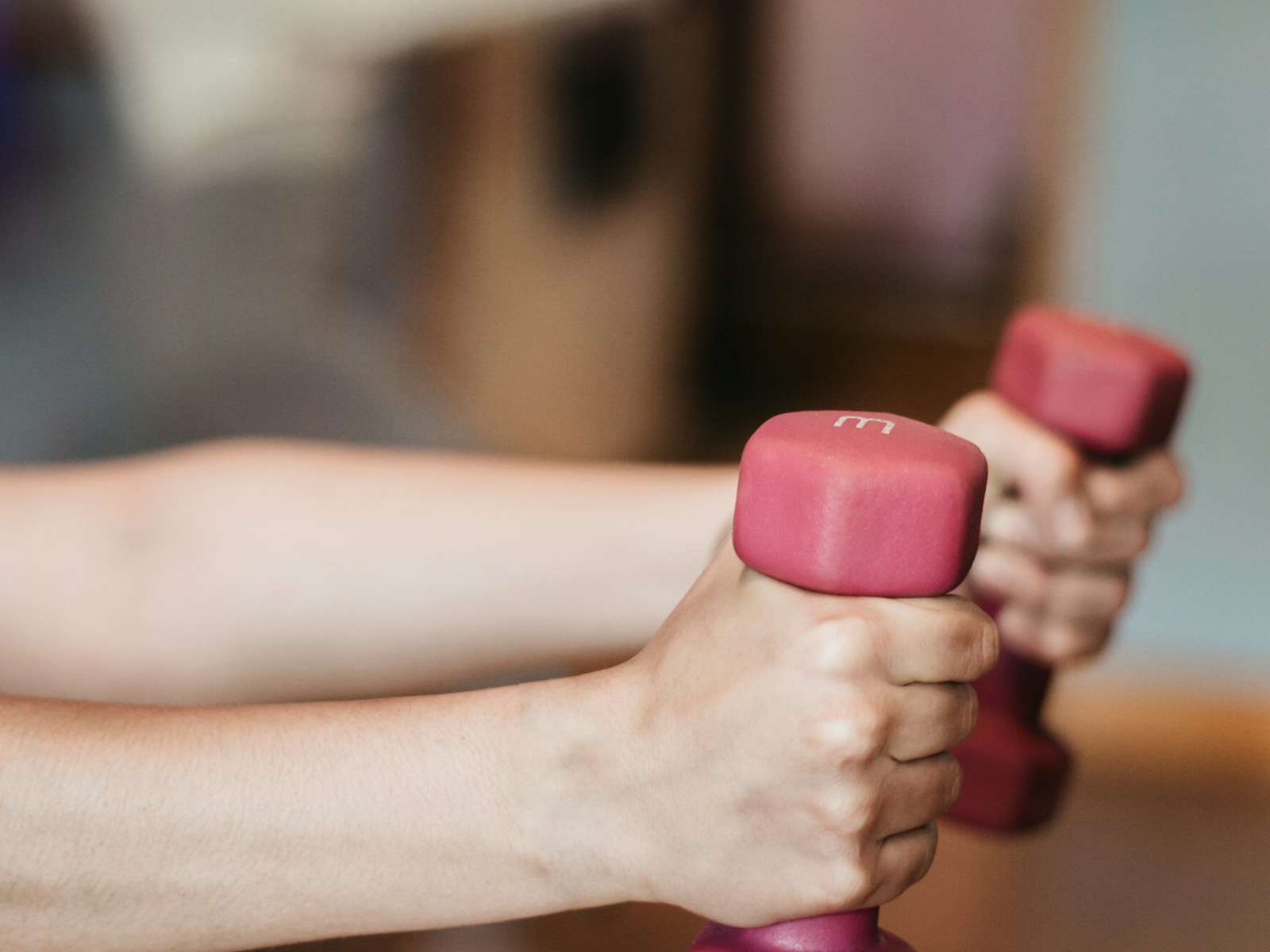 Hands holding light dumbbells